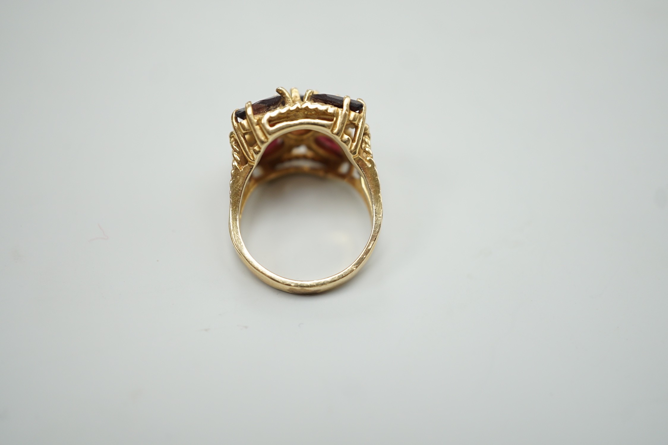 A modern 585 yellow metal and five stone garnet cluster set dress ring, size K/L